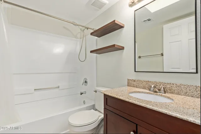 a bathroom with a granite countertop sink toilet and shower