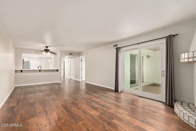a view of a big room with wooden floor and a ceiling fan