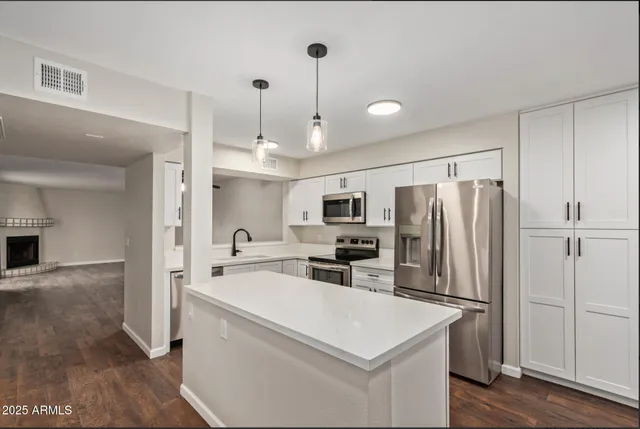 a kitchen that has a refrigerator a sink and a stove top oven