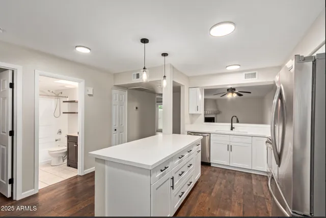 a kitchen with a sink a refrigerator and cabinets
