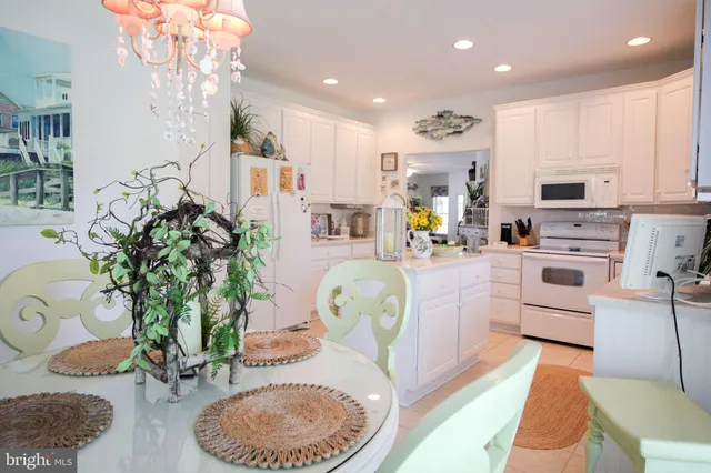 a bedroom with a bed chandelier and windows