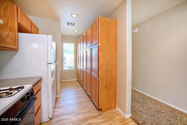 a view of a hallway with wooden floor and cabinets