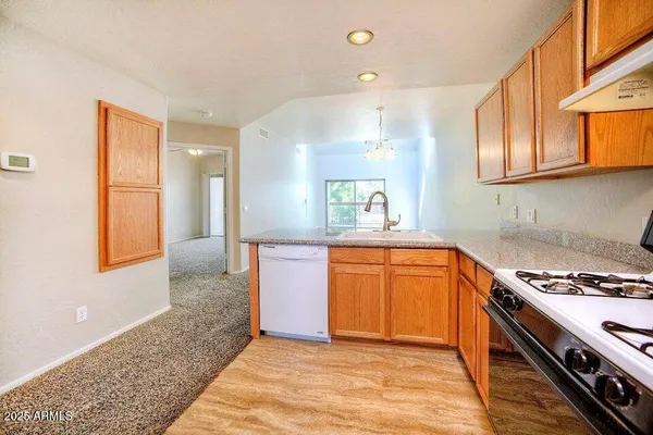 a kitchen with stainless steel appliances granite countertop a stove a sink and a refrigerator