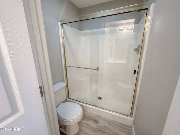 a bathroom with a granite countertop toilet and a shower