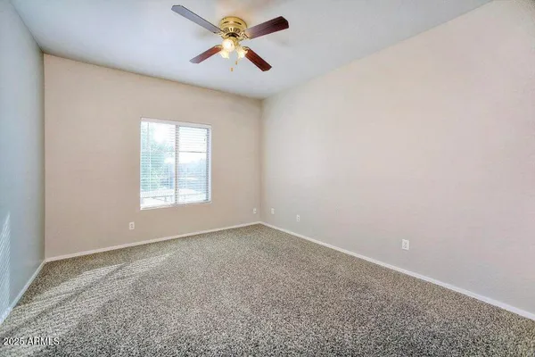 an empty room with a window and a fan