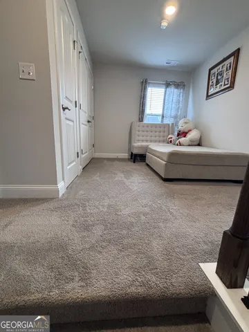 a bed sitting in a room next to a window and work place