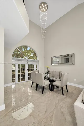 a living room with furniture a chandelier and a large window