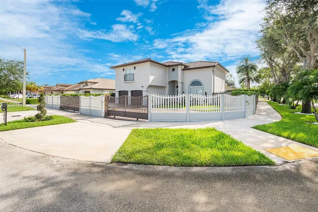 a front view of a house with a yard and potted plants