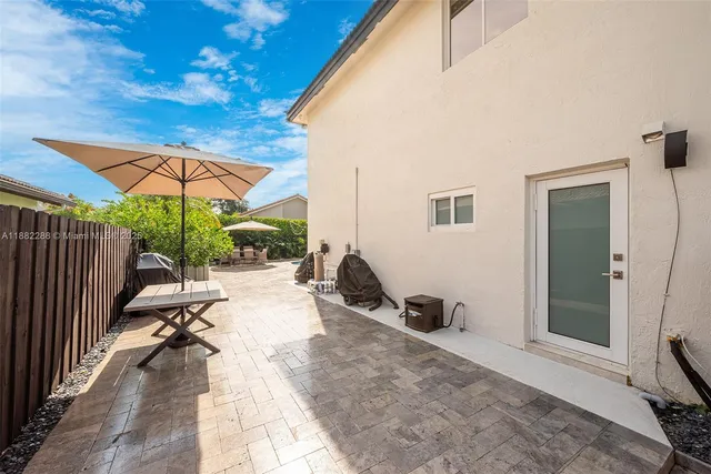 an outdoor sitting area with furniture and umbrella