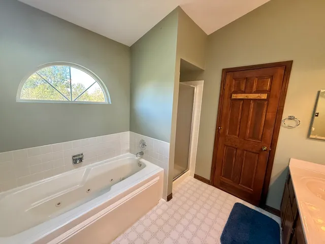 a bathroom with a bathtub and a window