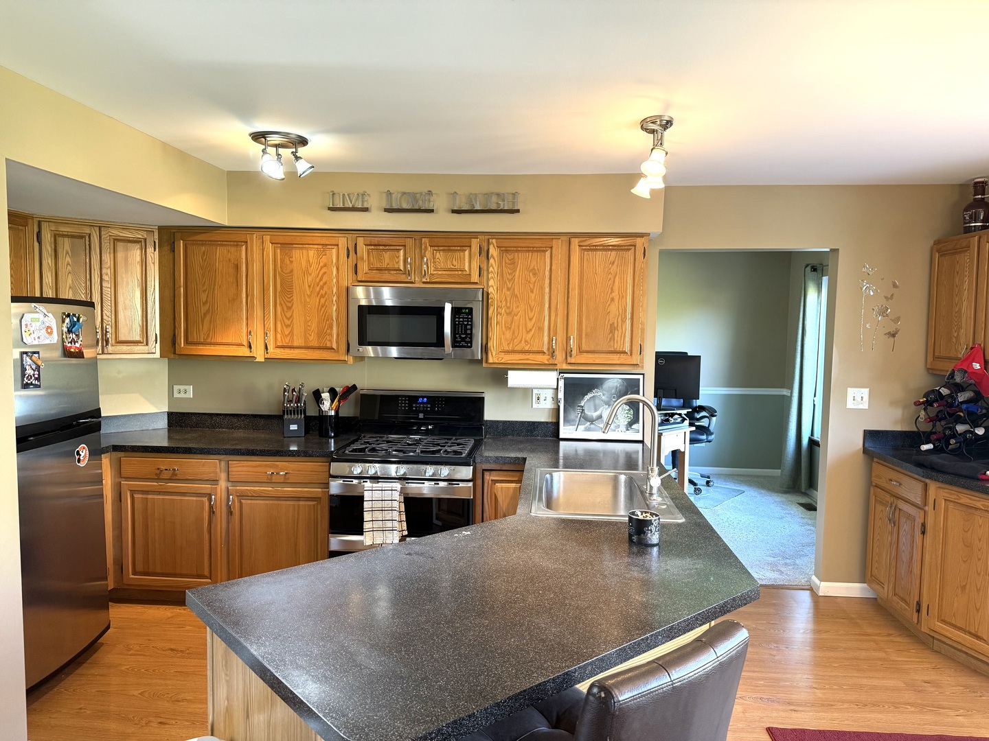 721 Mohican Trail Lake In The Hills, IL 60156 - Photo 4 of 20 a kitchen with a stove a sink a counter top space and living room view