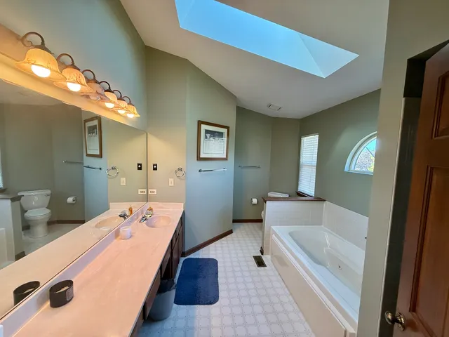 a large bathroom with a tub sink and mirror