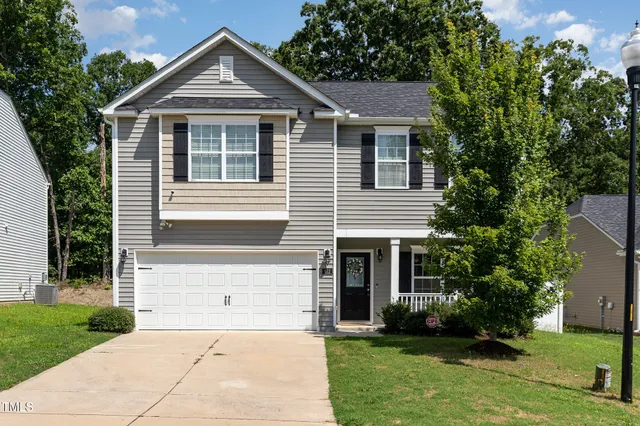 a front view of a house with a yard and garage