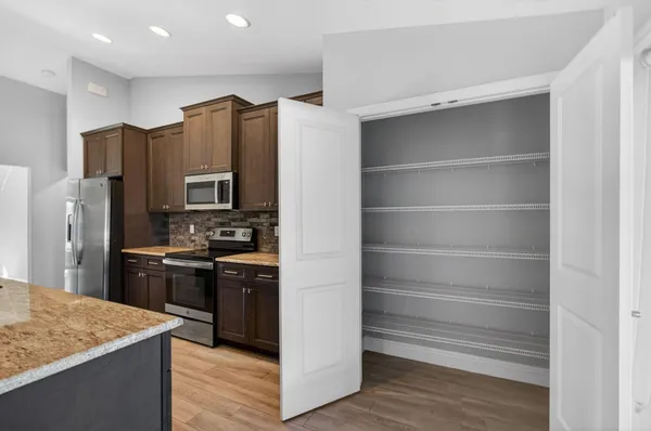 a kitchen with granite countertop a stove oven and wooden floors