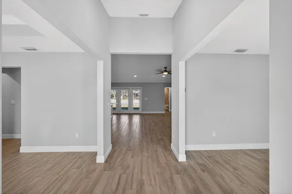 a view of an empty room with a window and wooden floor