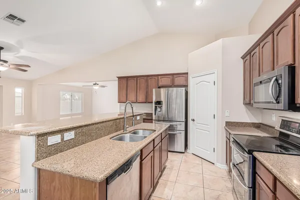 a kitchen with stainless steel appliances granite countertop a sink stove and refrigerator