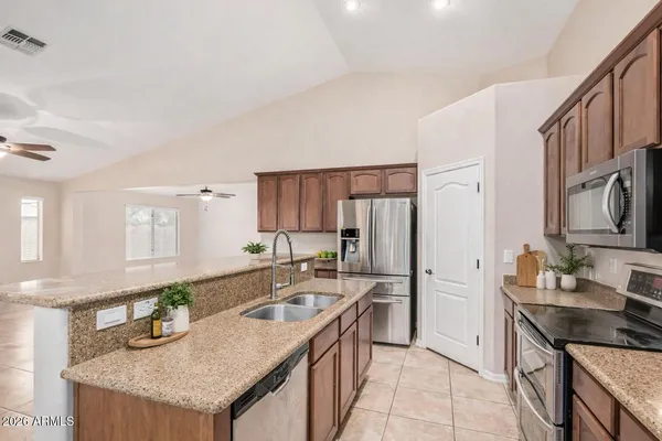 a kitchen with stainless steel appliances granite countertop a sink stove and refrigerator