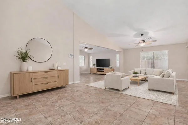 a living room with furniture a flat screen tv and a window