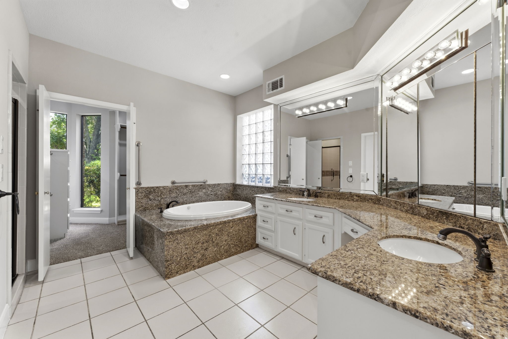 18503 Cabaniss Circle Spring, TX 77379 - Photo 26 of 49 The spacious primary bath features dual granite vanities, a jetted soaking tub, abundant counter space, and plenty of natural light.