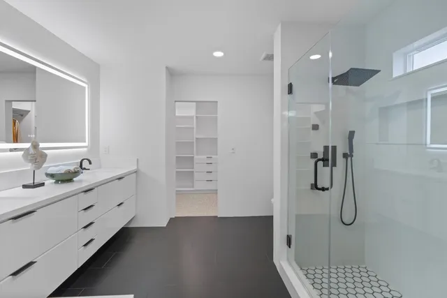 a view of a white house with a big yard and potted plants