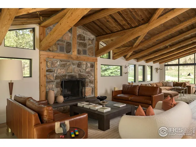a living room with furniture a fireplace and a large window