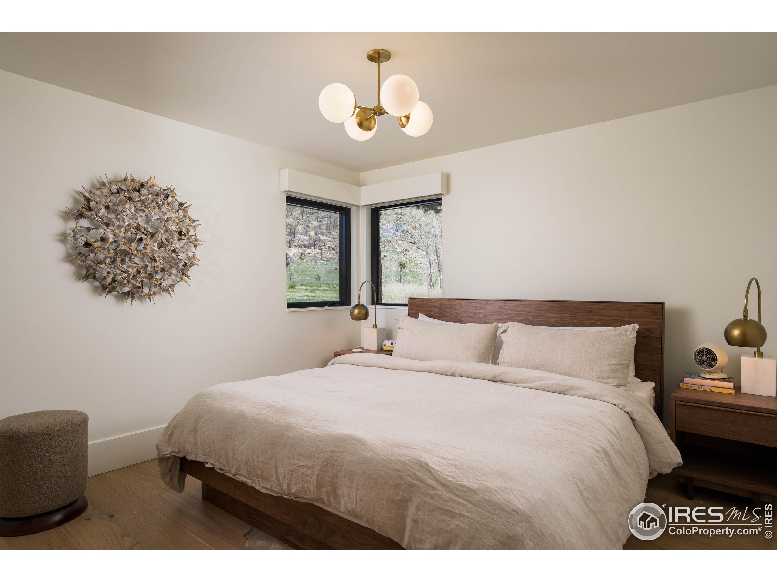 37797 W Highway Bellvue, CO 80512 - Photo 26 of 40 a bedroom with a bed and a chandelier