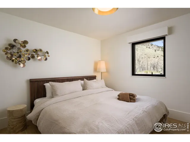 a bedroom with a bed and a painting on the wall