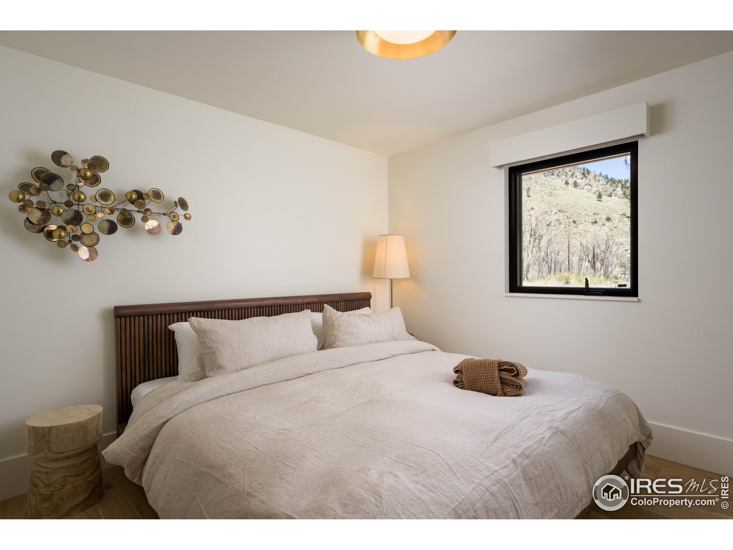 37797 W Highway Bellvue, CO 80512 - Photo 28 of 40 a bedroom with a bed and a painting on the wall