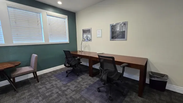a view of a workspace with furniture and a window