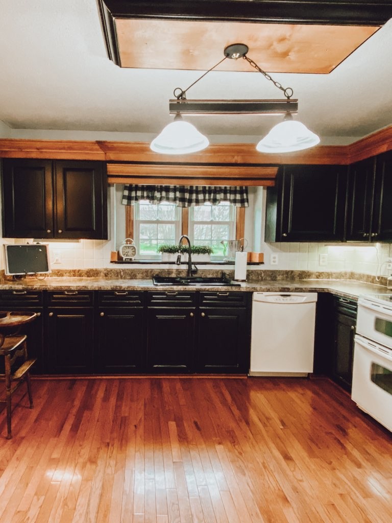 a large kitchen with granite countertop a stove and a wooden floors