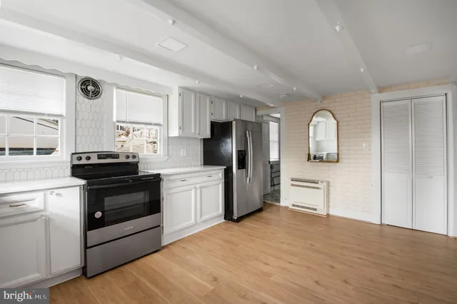 a kitchen with granite countertop a refrigerator stove top oven and sink