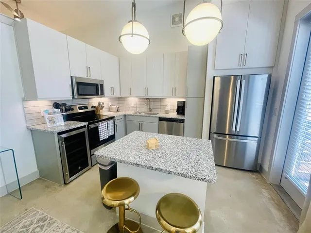 a kitchen with granite countertop a sink stove and refrigerator