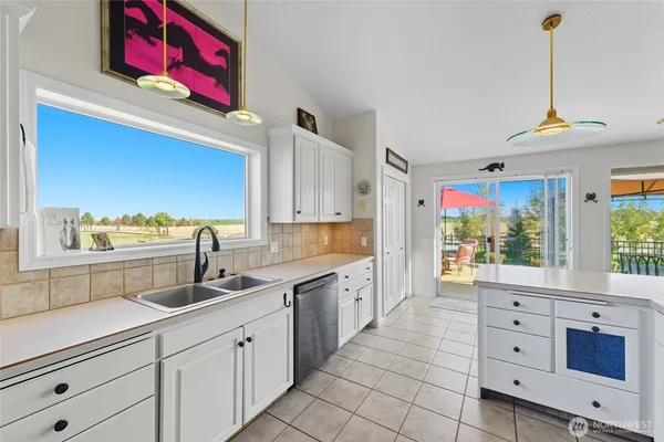a kitchen with white cabinets and window