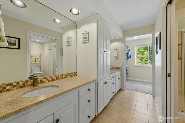 a spacious bathroom with a granite countertop sink and a large mirror