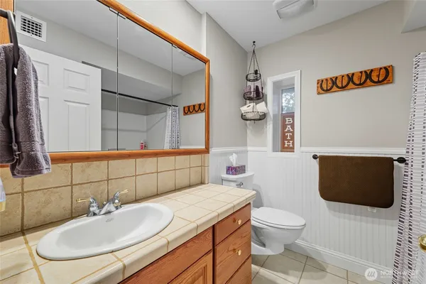 a bathroom with a sink toilet and mirror