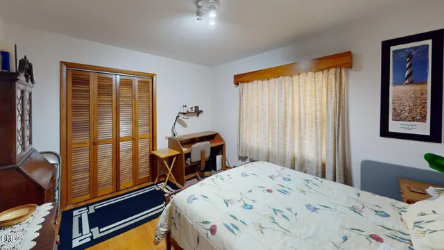 a bedroom with a bed and wooden floor