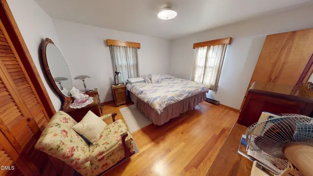 a bedroom with two beds and wooden floor