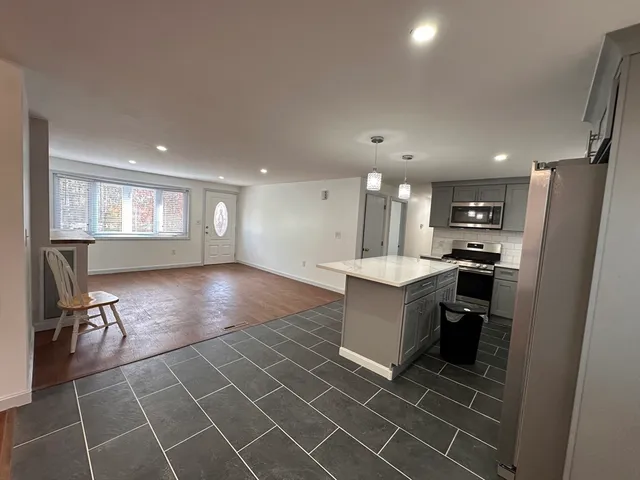 a kitchen with stainless steel appliances granite countertop a refrigerator and a stove top oven
