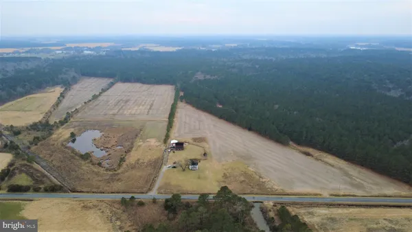 an aerial view of a house with a yard and mountain in the back