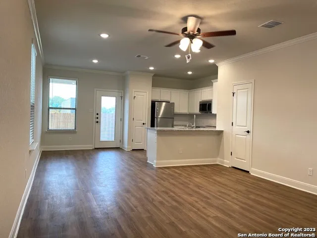 a view of kitchen with granite countertop cabinets and refrigerator