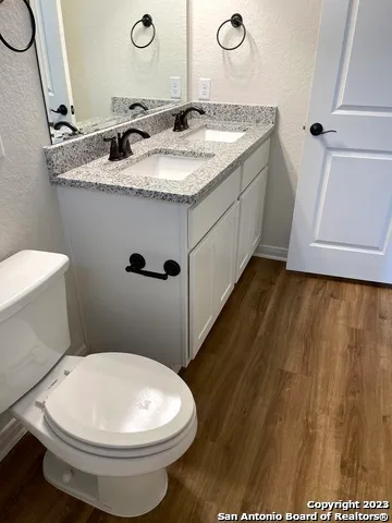 a bathroom with a granite countertop sink toilet and mirror