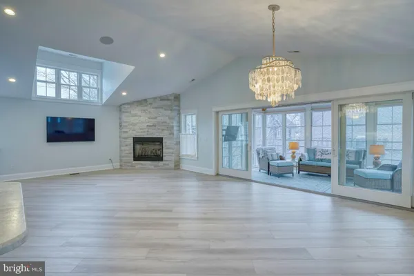 an empty room with wooden floor fireplace and windows