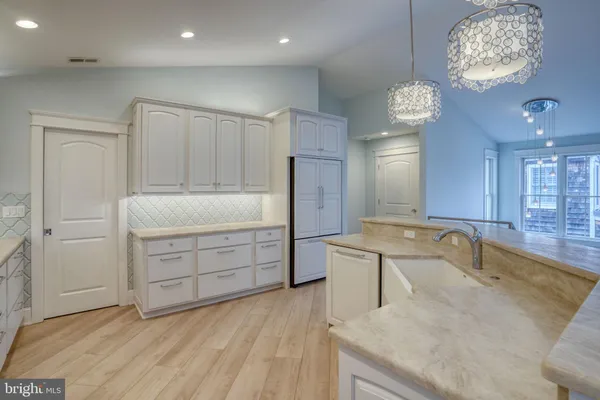 a kitchen with stainless steel appliances granite countertop a sink a stove and a wooden floors