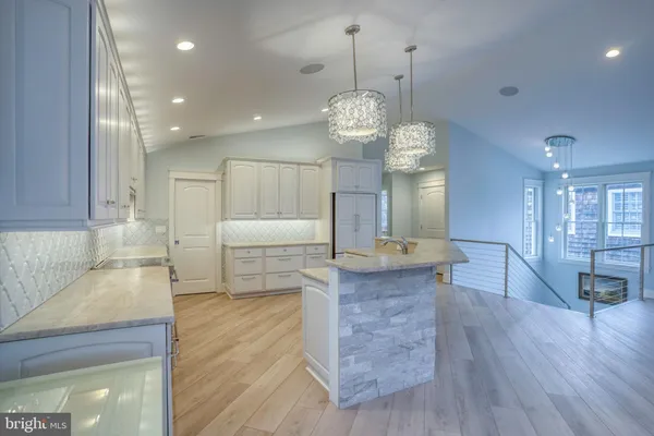 a large kitchen with stainless steel appliances granite countertop a oven a stove and a wooden floors