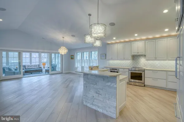 a large kitchen with stainless steel appliances granite countertop a sink a stove and a large refrigerator