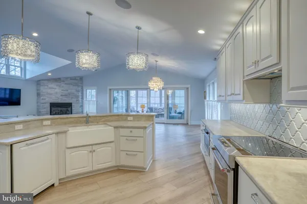 a large kitchen with white cabinets and stainless steel appliances