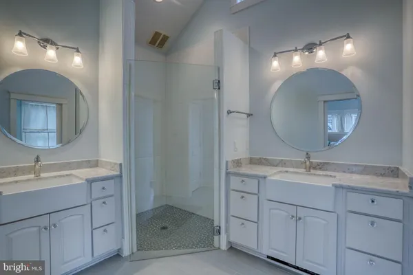 a bathroom with a double vanity sink mirror and shower
