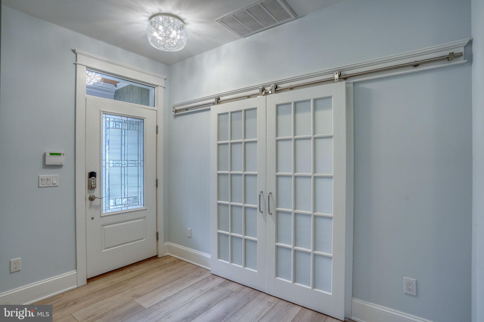 237 2nd Street Lewes, DE 19958 - Photo 8 of 52 a view of an empty room with wooden floor and a window