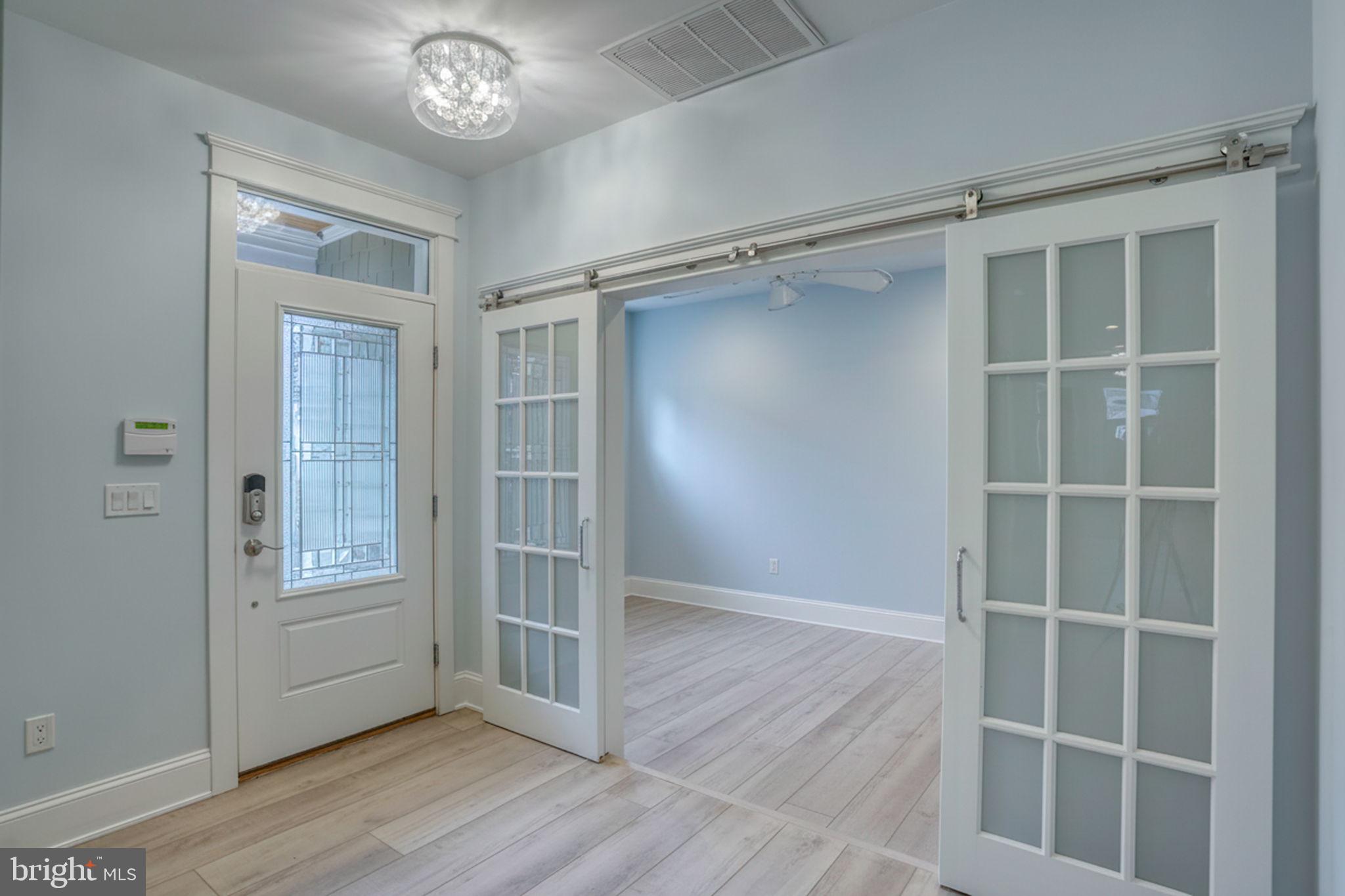 237 2nd Street Lewes, DE 19958 - Photo 9 of 52 a view of an empty room with wooden floor and a window
