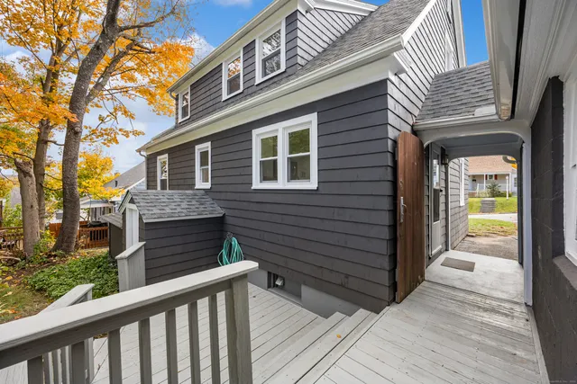 a view of a house with a deck and a floor to ceiling window